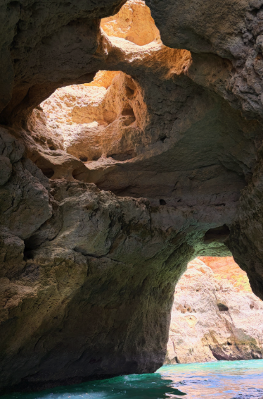 Sunlight falling through the Benagil skylight onto the hidden beach